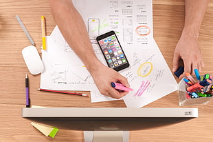 person holding highlighter on desk
