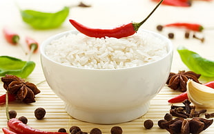 cooked rice with red chili pepper on top