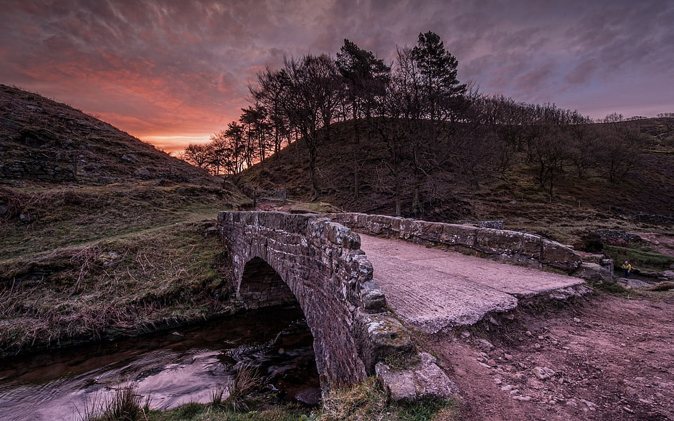 gray concrete bridge near hill at sunset HD wallpaper