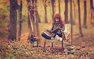 woman reading book under trees during daytime HD wallpaper