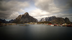 city surrounded by body of water and brown snow top covered mountain during day time, reine, norway