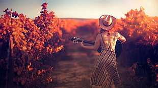 woman holding guitar near brown plants HD wallpaper