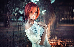 photo of woman leaning mesh fence