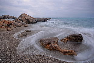 brown sea shore rocks during daytime HD wallpaper