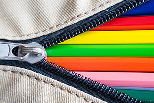 close-up photography of brown zipper with multi-colored illustration