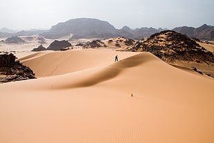 person standing on desert hill during daytime