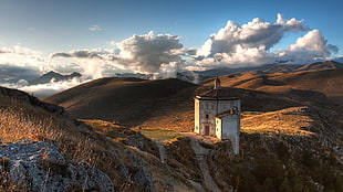 concrete house at the edge of the mountain during day, landscape, Spain, clouds, sky