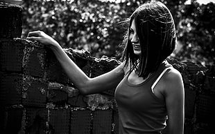 grayscale photo of woman holding concrete wall while smiling HD wallpaper