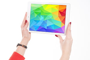 person holding white iPad mini HD wallpaper