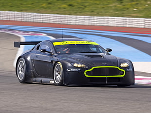 black and green Aston Martin Vantage speeding on race track during daytime