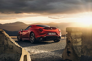 red sports car on gray asphalt road during sunset