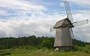 photo of windmill with grass field and trees in the background