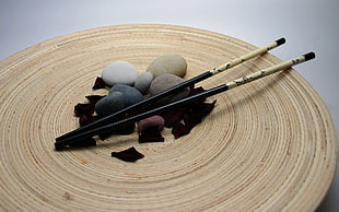 black and gray fishing rod, chopsticks, stones