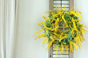 green and yellow beaded wreath near white curtain
