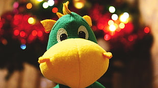 closeup photo of green and yellow animal plush toy