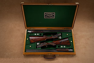 brown bolt action rifle in brown wooden chest box