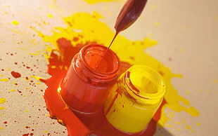 red and yellow paint on clear glass containers