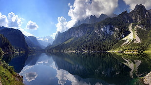 landscape photography of lake between mountain range under blue sky and white clouds