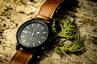 round black chronograph watch with brown leather strap