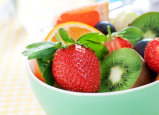 selective focus photography of strawberry and kiwi in bowl