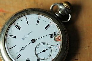 round pocket watch with silver-colored case