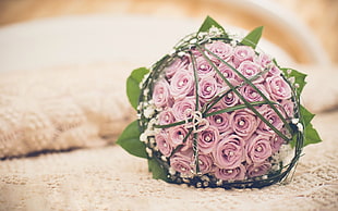 photography of organized pink roses bouquet on beige knitted textile