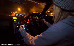 woman holding steering wheel during nighttime