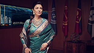 woman wearing blue and grey sari traditional dress beside three flags and wall