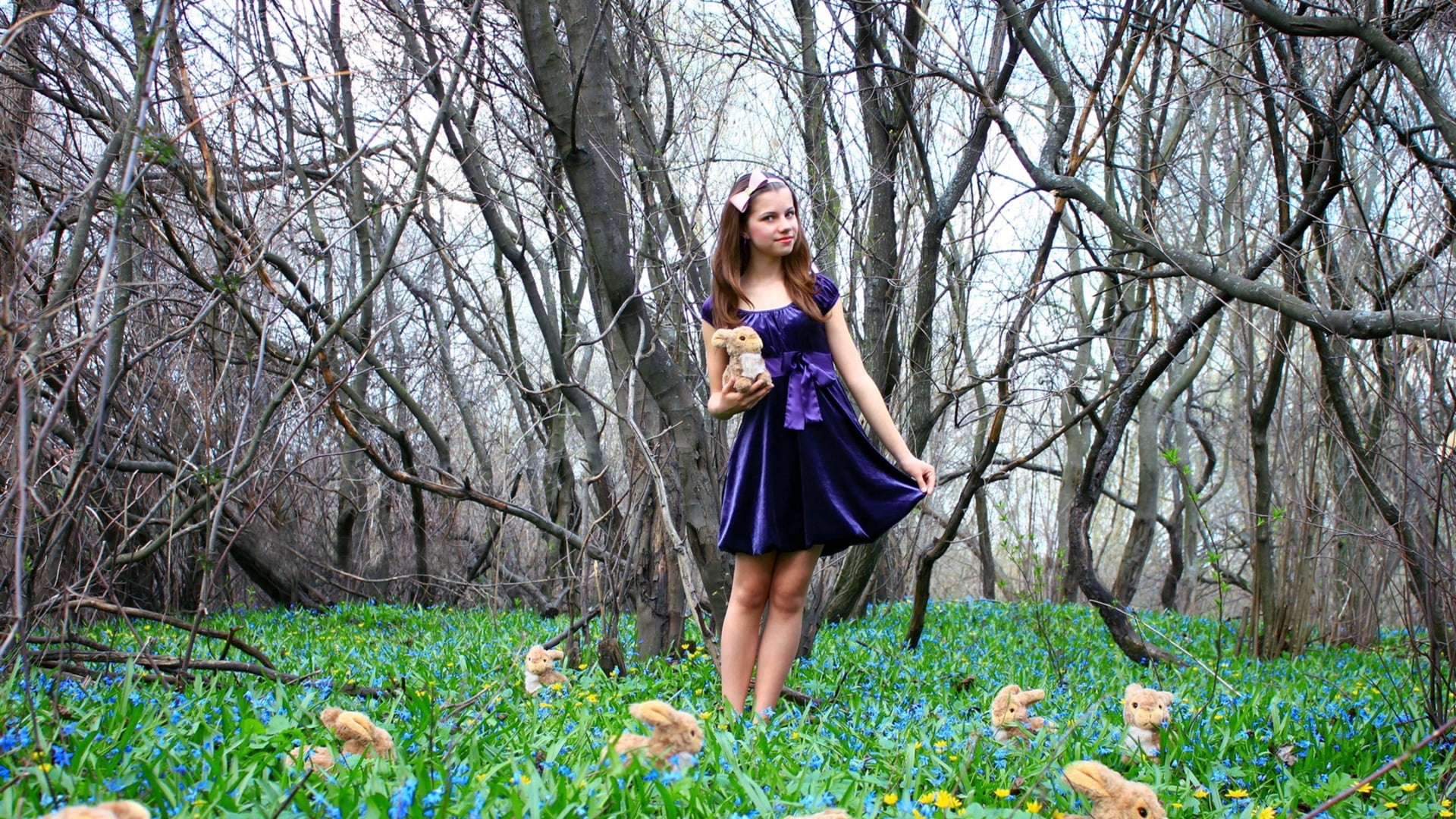 girl wearing purple satin dress standing in middle of forest