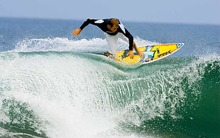man on surfboard surfing ocean wave