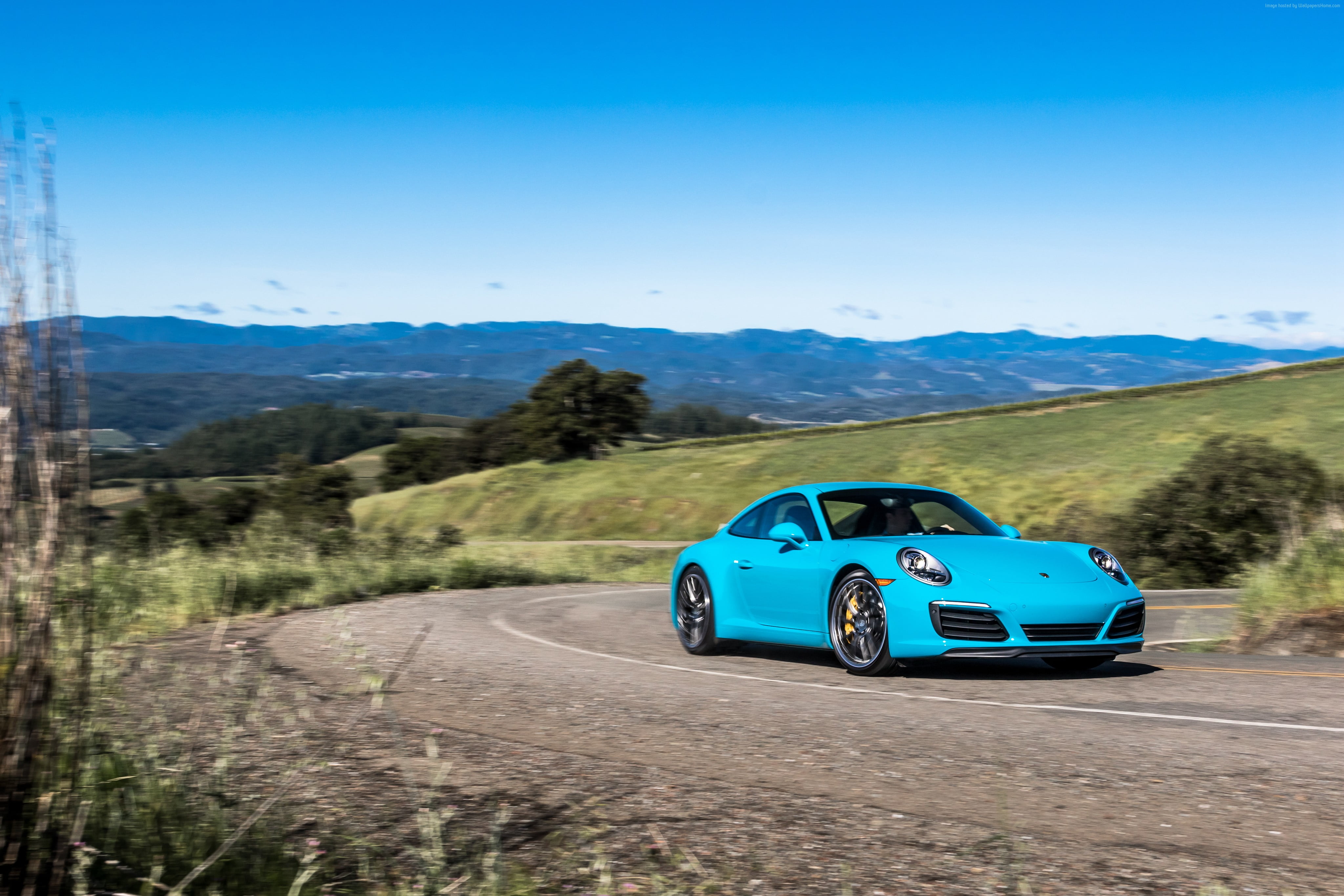 blue Porsche coupe on gray road