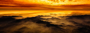 black smoky mountains under orange skies HD wallpaper