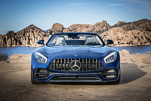 blue Mercedes-Benz AMG GT4 convertible on gray road