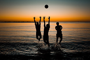 silhouette of 3 people with ball during sunset HD wallpaper