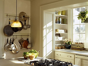assorted frying pans on wall inside kitchen during daytime
