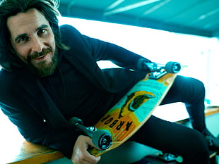 man holding skateboard HD wallpaper