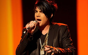 man wearing black leather jacket while singing