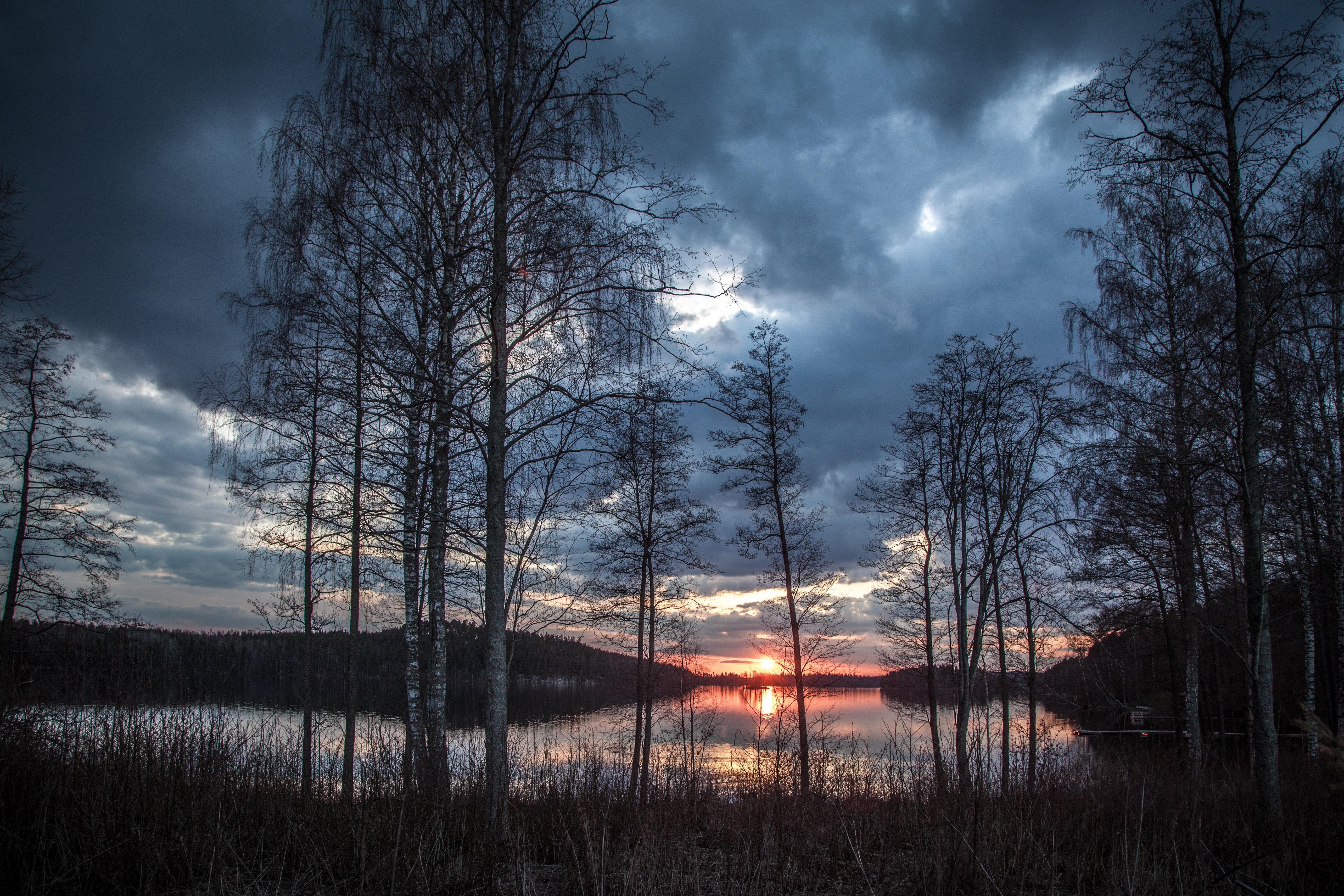 Ранний вечер время. Озеро Паасселка, Финляндия. Финляндия, огни озера Паасселка. Лес вечером. Весенний закат.