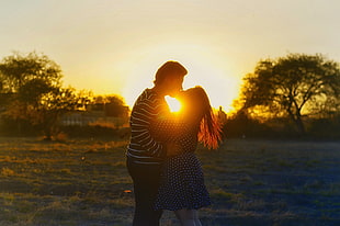 man and woman kissing during golden hour HD wallpaper