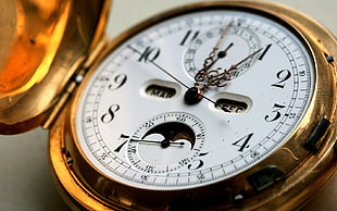 close-up photo of round gold-colored pocket watch
