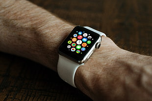 person with silver aluminum Apple Watch with white sports band turned one