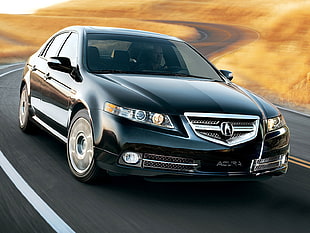 black Acura TL crossing road during daytime