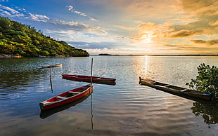 photo of two red and brown canoe boats, lagoa, barra, laguna