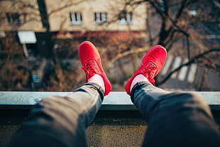 red lace-up low-top sneakers, red shoes, legs, depth of field, rooftops