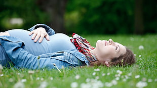 woman laying on grass field