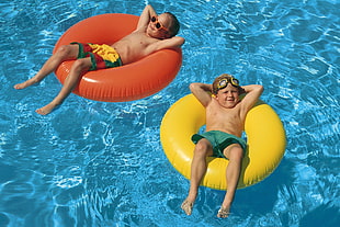 two boys floating in swimming rings