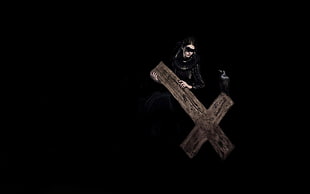 woman in black coat holding cross