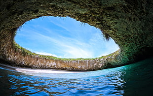 body of water with cave during daytime