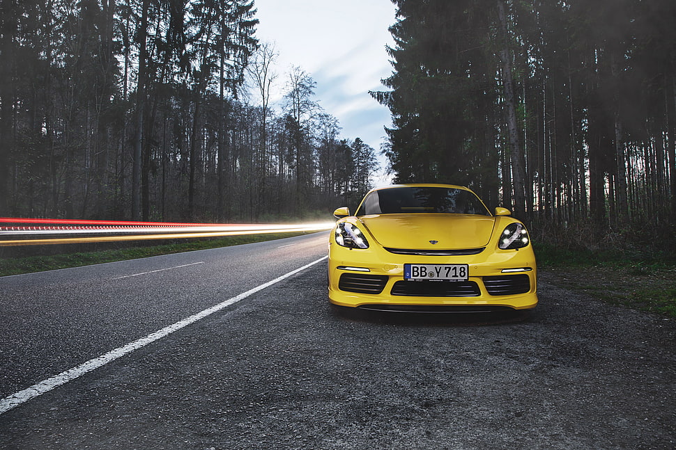 yellow Porsche sports car on concrete road HD wallpaper