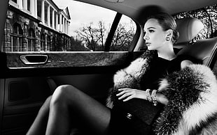 grayscale photography of woman in dress inside car